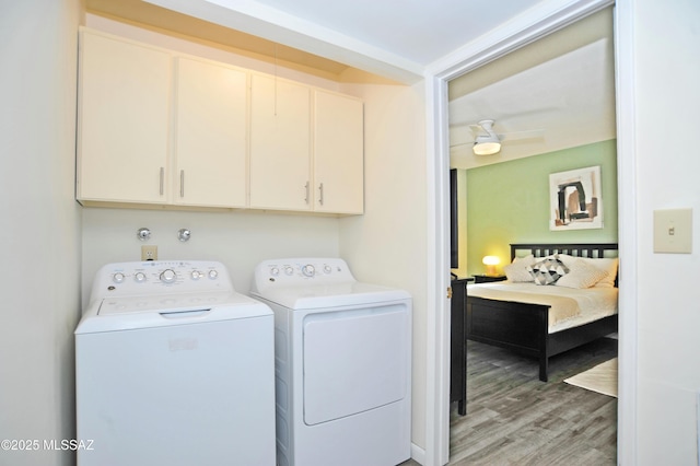 laundry area with independent washer and dryer, light hardwood / wood-style floors, and cabinets