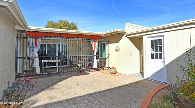 view of exterior entry with a patio area