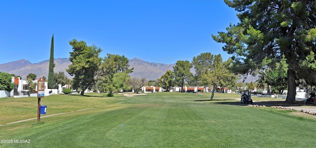 view of home's community with a mountain view and a yard