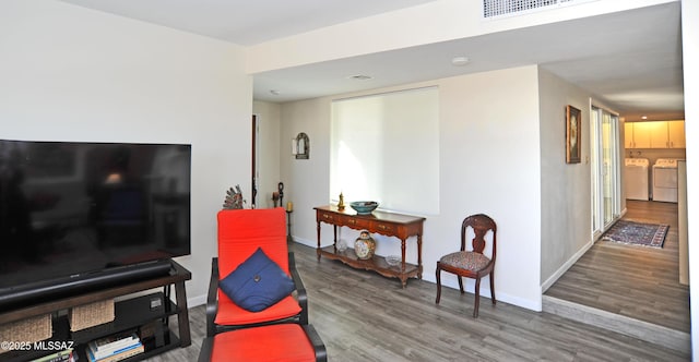 sitting room featuring hardwood / wood-style flooring and washing machine and clothes dryer