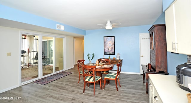 dining space with ceiling fan and light wood-type flooring