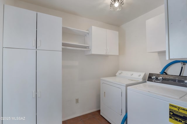 laundry room featuring cabinets, separate washer and dryer, and dark tile patterned flooring