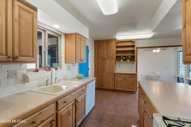 kitchen featuring dark tile patterned floors, white dishwasher, sink, and backsplash