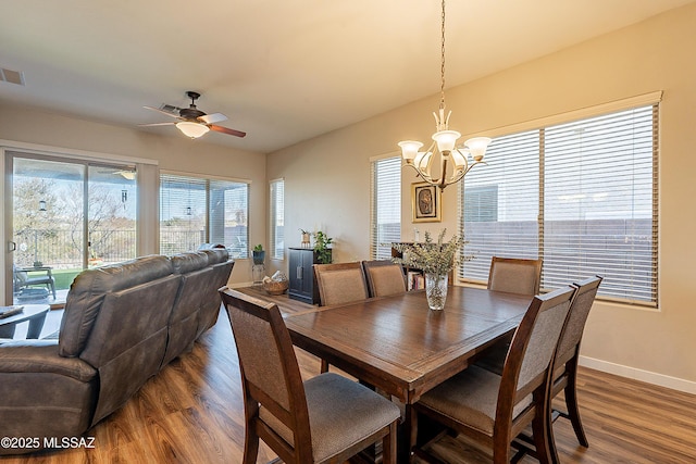 dining room featuring ceiling fan with notable chandelier and dark hardwood / wood-style flooring