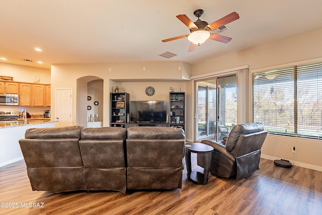 13774 N High Mountain View Pl, Tucson, AZ 85739 - living area featuring arched walkways, a ceiling fan, light wood-type flooring, and recessed lighting