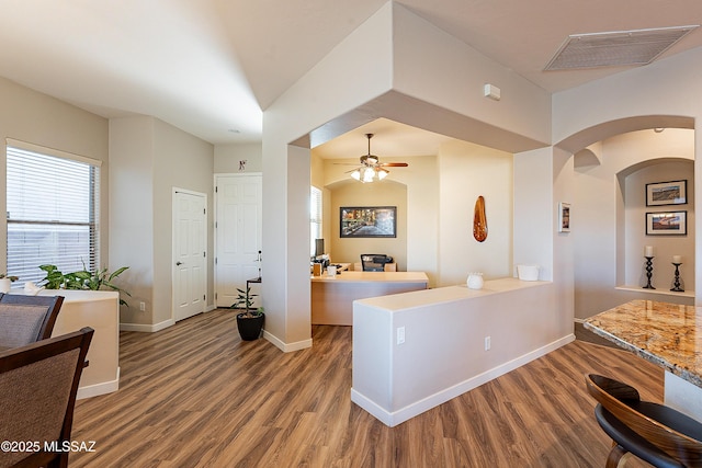 kitchen with hardwood / wood-style floors, kitchen peninsula, and ceiling fan