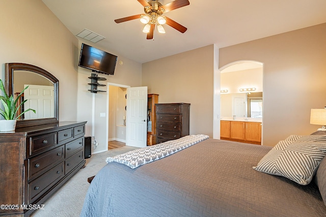 bedroom with light carpet, connected bathroom, and ceiling fan