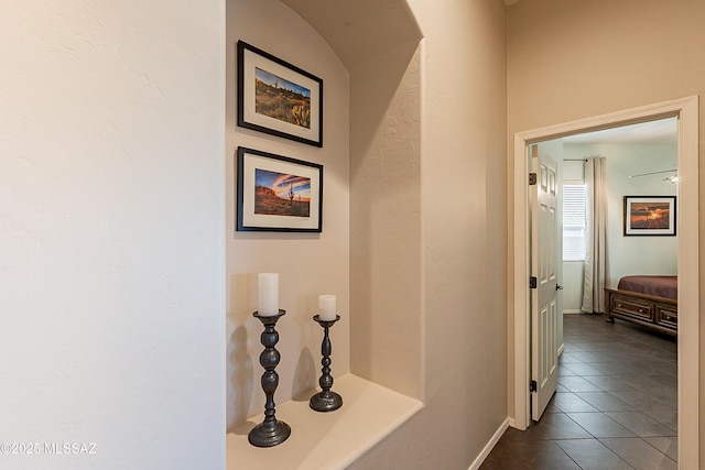 corridor featuring dark tile patterned flooring