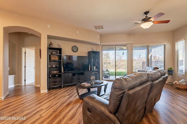 living room featuring wood-type flooring and ceiling fan