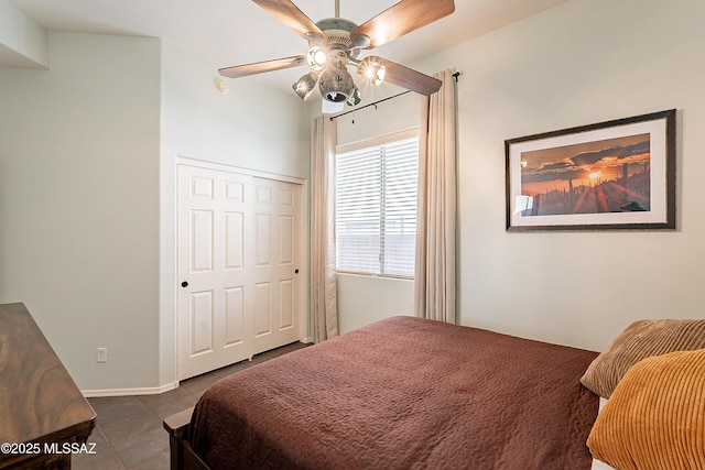 tiled bedroom featuring ceiling fan and a closet