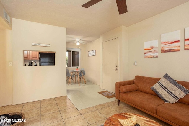 living room with ceiling fan and light tile patterned flooring