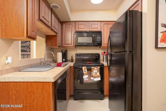 kitchen featuring light tile patterned flooring, sink, and black appliances