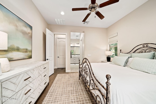 bedroom with ceiling fan, ensuite bathroom, and dark hardwood / wood-style floors