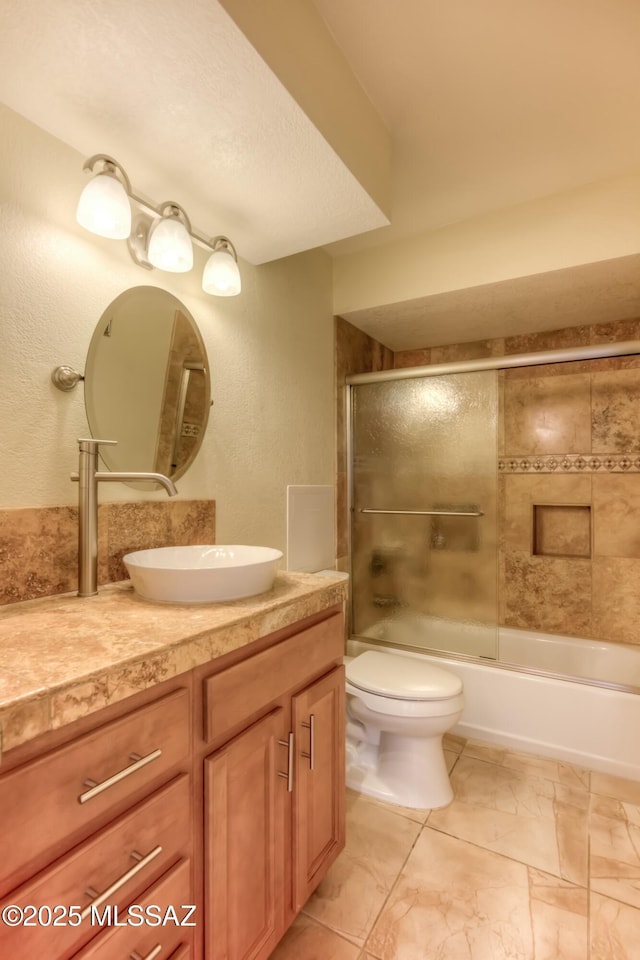 full bathroom with vanity, toilet, and combined bath / shower with glass door