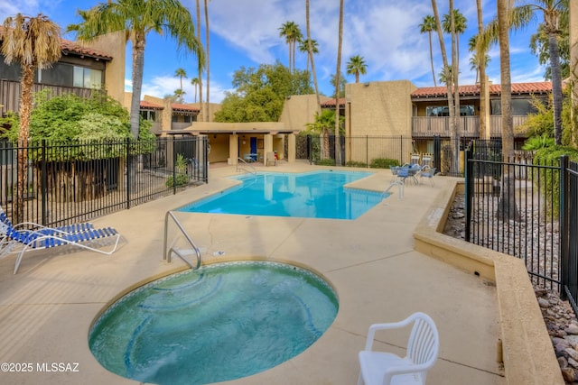 view of swimming pool featuring a community hot tub and a patio area