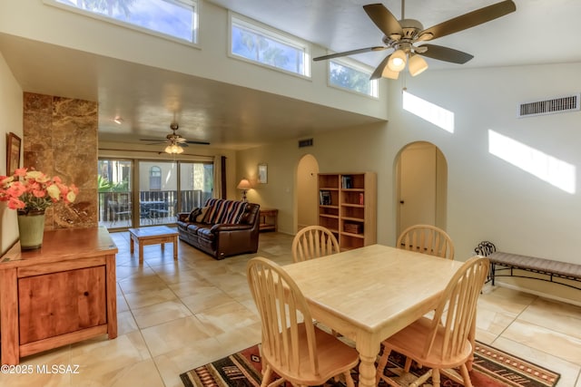 dining area with a towering ceiling and ceiling fan