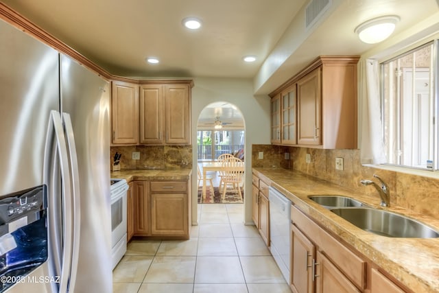 kitchen featuring sink, white appliances, light tile patterned floors, ceiling fan, and decorative backsplash