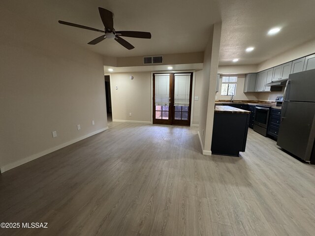 kitchen with stainless steel appliances, butcher block counters, and light hardwood / wood-style floors