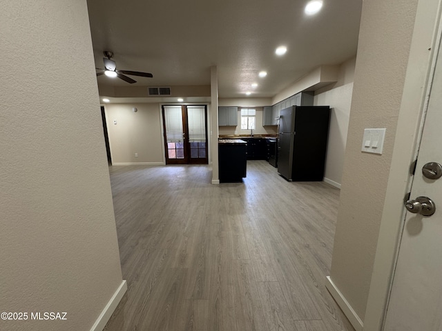 kitchen with sink, light hardwood / wood-style flooring, ceiling fan, refrigerator, and french doors