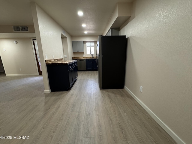 kitchen featuring stainless steel appliances, gray cabinetry, and light wood-type flooring