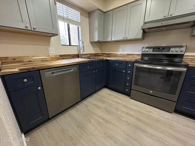 kitchen featuring stainless steel appliances, butcher block counters, and light wood-type flooring