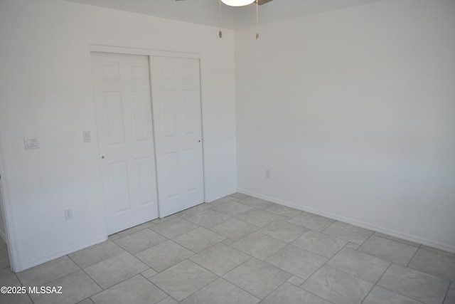 unfurnished bedroom with ceiling fan and a closet