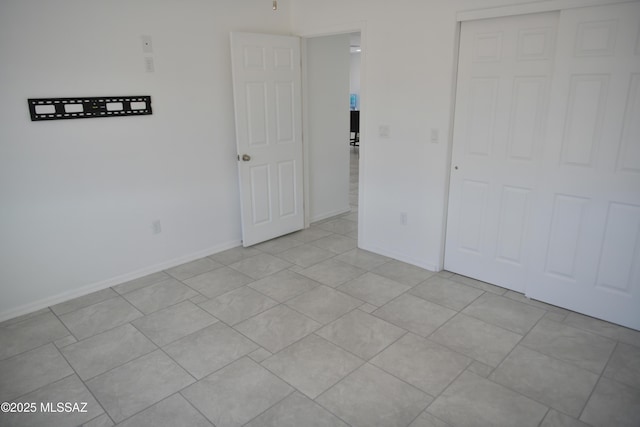 unfurnished bedroom featuring a closet and light tile patterned floors