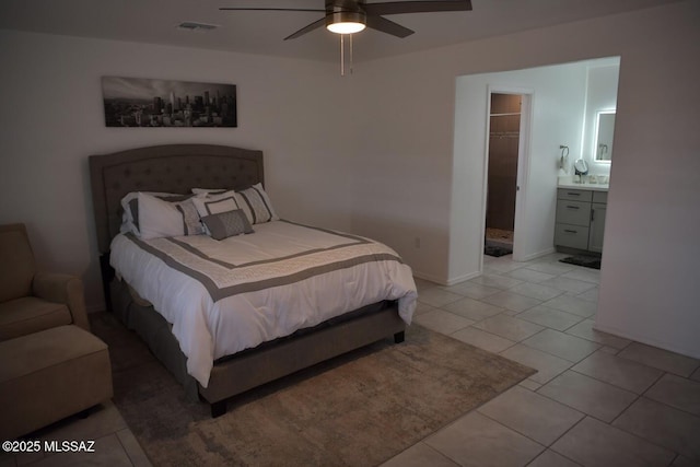 bedroom featuring ceiling fan, light tile patterned floors, and ensuite bath