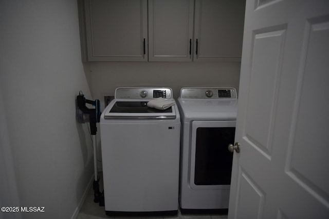 washroom with washing machine and dryer and cabinets