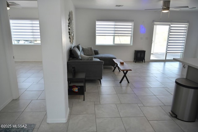 tiled living room featuring ceiling fan and plenty of natural light