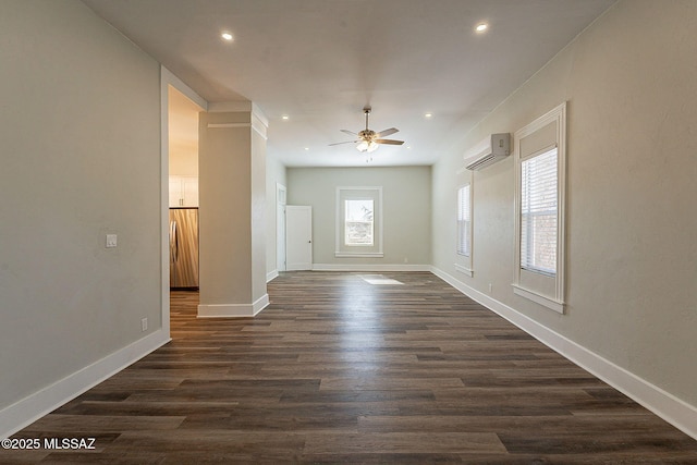 interior space with dark wood-type flooring, a wall unit AC, and ceiling fan