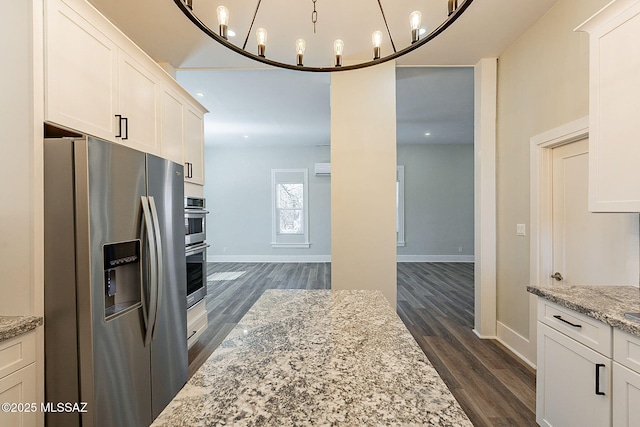 kitchen with white cabinetry, light stone counters, dark hardwood / wood-style floors, and appliances with stainless steel finishes