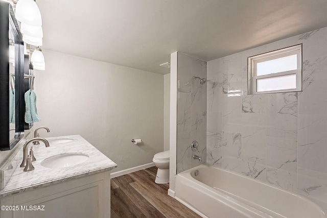 full bathroom featuring tiled shower / bath combo, vanity, hardwood / wood-style floors, and toilet
