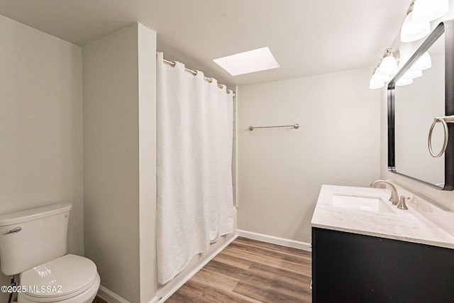 full bathroom with shower / bath combo, hardwood / wood-style floors, a skylight, vanity, and toilet