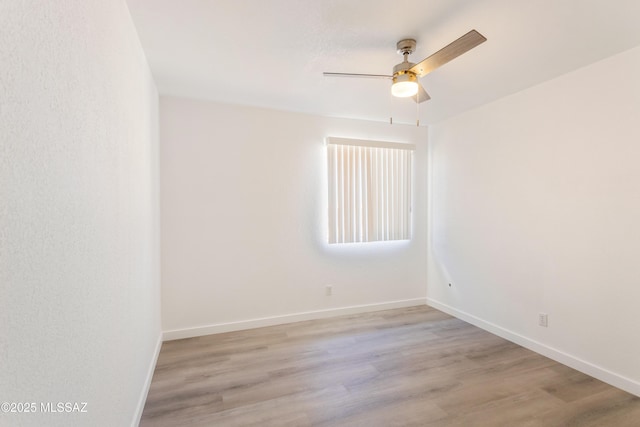 empty room with ceiling fan and light hardwood / wood-style flooring