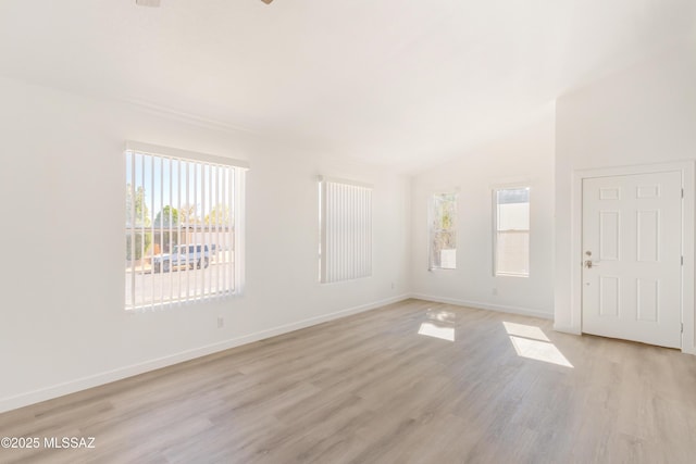 unfurnished room featuring lofted ceiling and light hardwood / wood-style flooring