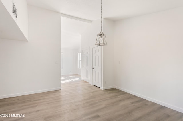 unfurnished dining area with high vaulted ceiling and light hardwood / wood-style flooring