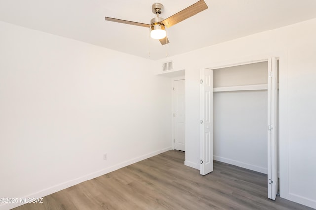 unfurnished bedroom featuring dark wood-type flooring, a closet, and ceiling fan