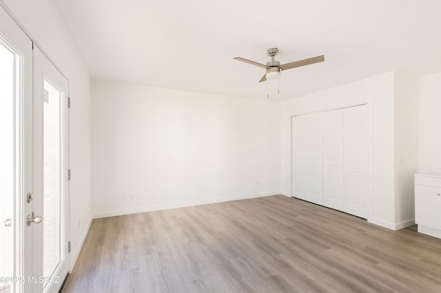 empty room with ceiling fan and light hardwood / wood-style floors