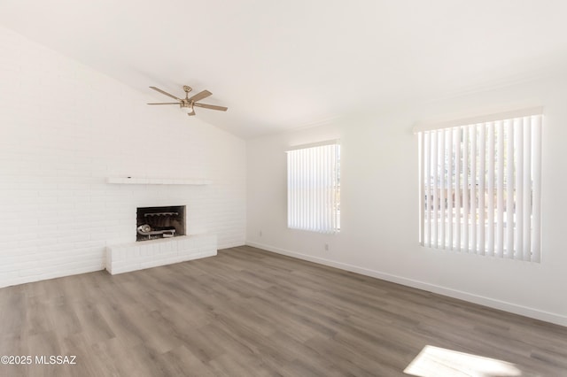 unfurnished living room featuring ceiling fan, wood-type flooring, a fireplace, and vaulted ceiling