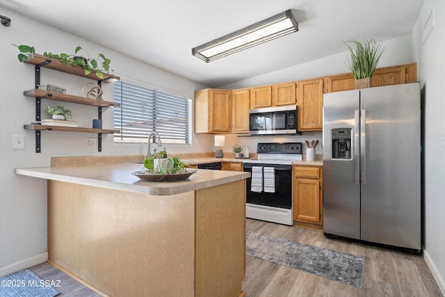 kitchen featuring lofted ceiling, light hardwood / wood-style flooring, stainless steel appliances, and kitchen peninsula