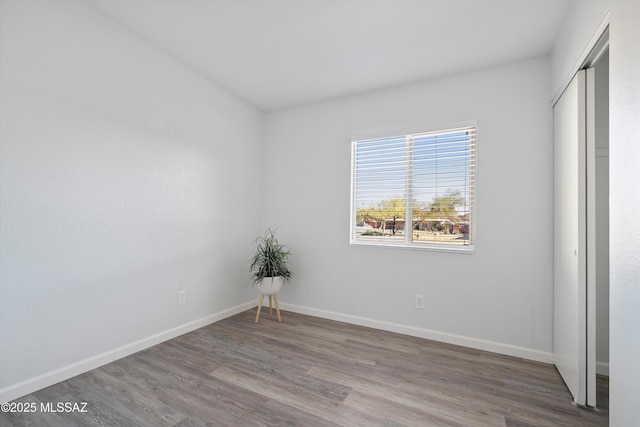 unfurnished bedroom with hardwood / wood-style flooring and a closet