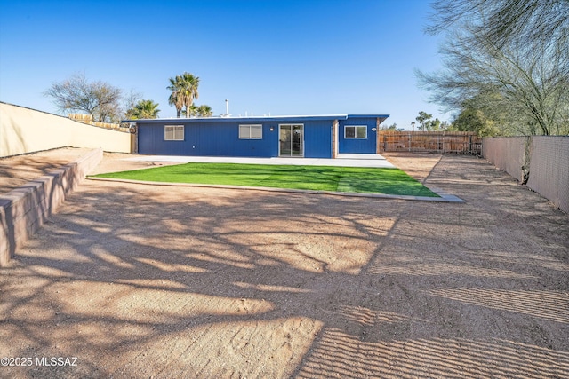 rear view of property with a patio and a lawn