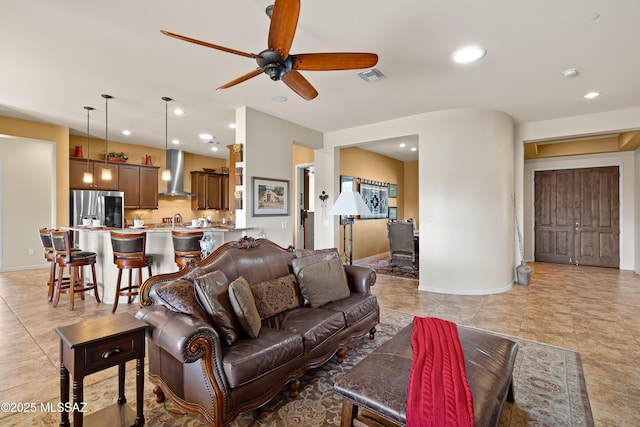 living room featuring light tile patterned flooring, sink, and ceiling fan