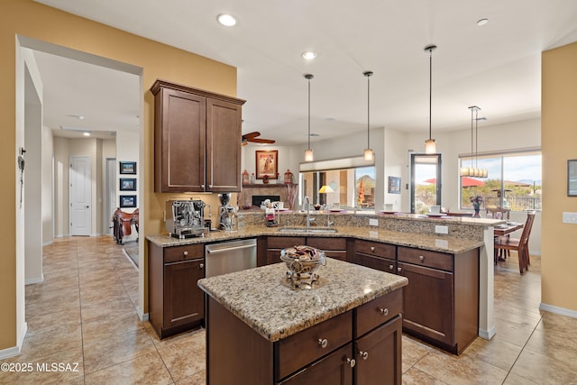 kitchen featuring dishwasher, kitchen peninsula, sink, and a kitchen island