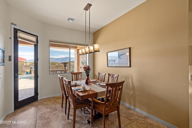 dining area with tile patterned floors and an inviting chandelier