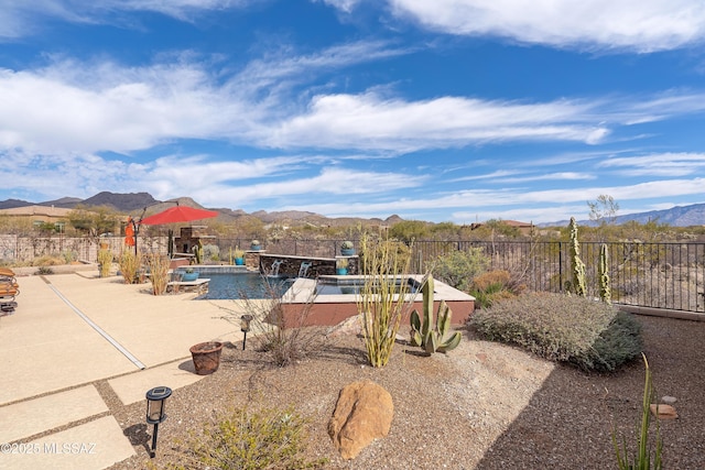 view of swimming pool featuring a mountain view, pool water feature, and a patio area