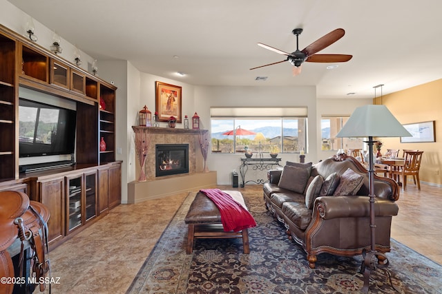 living room with a mountain view, tile patterned floors, and ceiling fan