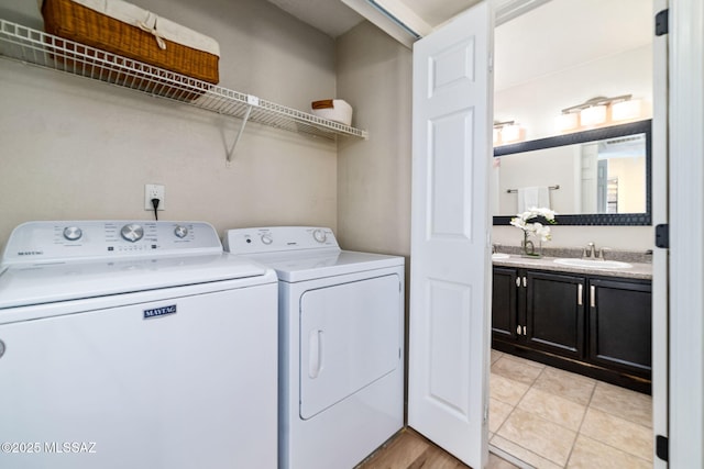 washroom with sink, washing machine and dryer, and light tile patterned flooring