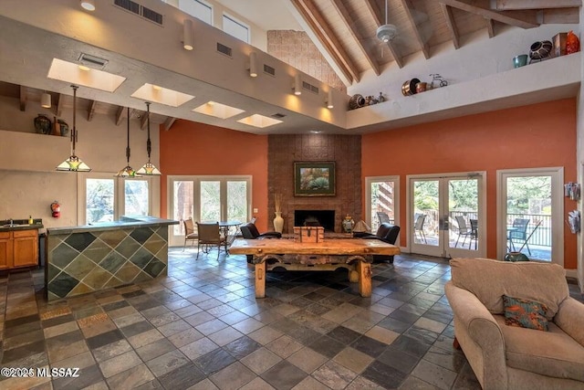 rec room with french doors, beam ceiling, and high vaulted ceiling